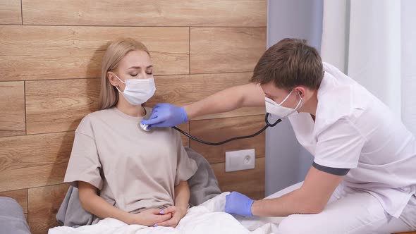 Male Doctor is Listening to Breath of Female Patient