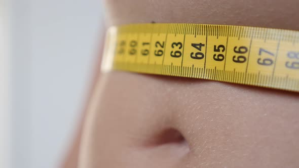 Taking woman waist circumference with yellow measure tape 4K 2160p 30fps UHD footage - Measuring  lo alt