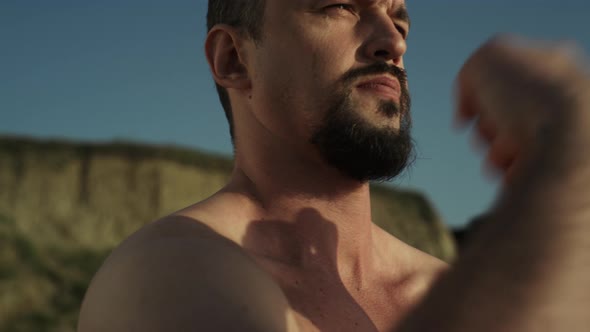 Closeup Bearded Karate Man Naked Body Warming Up on Seashore Summer Day alt