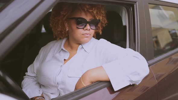 Happy Young Smiling African American Woman Red Afro Haired Driver in Sun Glasses Sitting in New