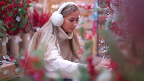 Christmas Shopping European Woman Choose Branches for Christmas Wreath Indoor in Supermarket alt