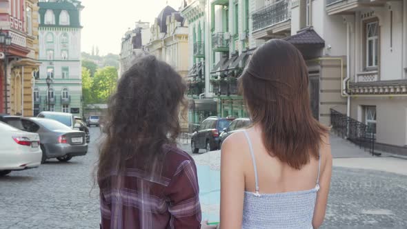 Cheerful Female Friends Smiling To the Camera While Wandering in the City