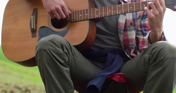 Close Up Of Man Hands Playing Guitar During Camping By Zonecreative