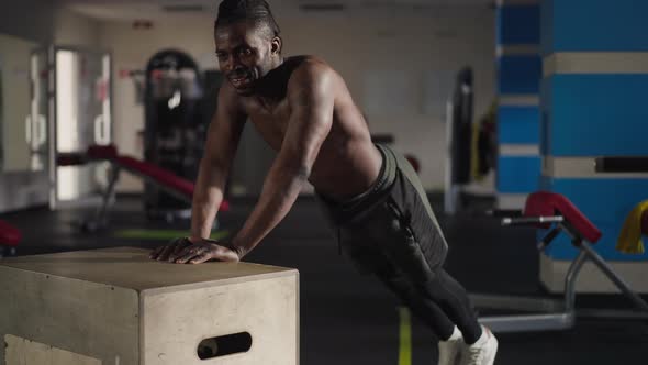 Strong Handsome African American Man Doing Pushups on Gym Cube Wide Shot alt