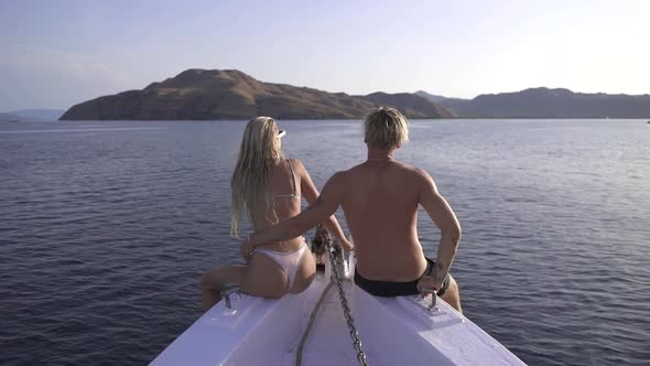Couple Sitting On The Edge Of A Boat