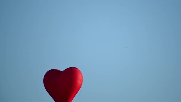 Colorful Hotair Heart Shape Balloon Flying on Sunset Over Blue Sky in Slow Motion Happy Valentines alt