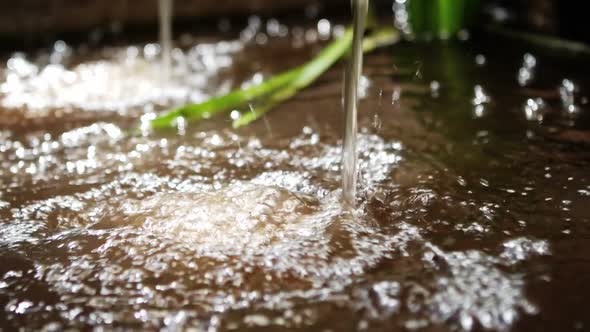 Water flowing from tap into pool alt