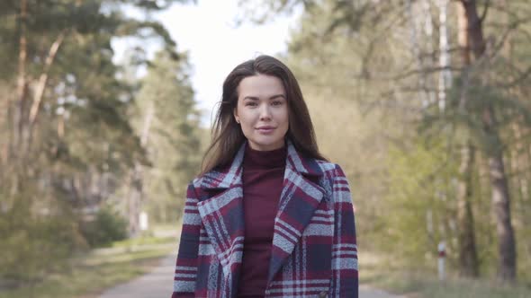 Portrait of Confident Brunette Girl Walking To Camera Along Empty Small Road. Positive Brown-eyed alt