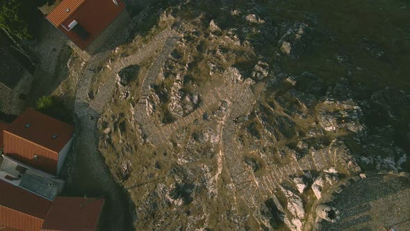 Drone lowers over the stone path at the Folgosinho Castle in Portugal. alt