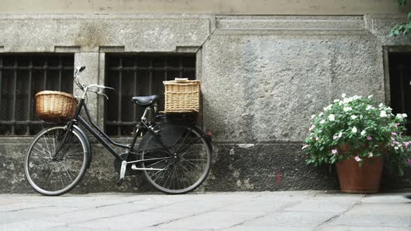 Bicycle and flowers next to a building in Milan Italy. alt
