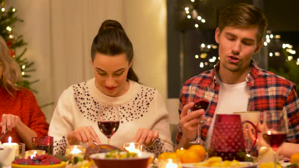 Happy Friends Having Christmas Dinner at Home alt