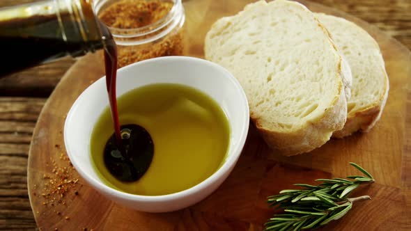Bread, rosemary and soy sauce being poured in olive oil alt