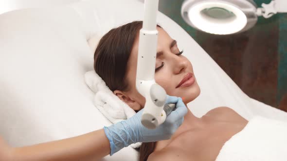 Woman at Beauty Clinic Receiving Facial Treatment alt