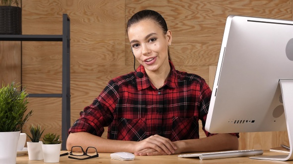 Beautiful consultant of call center talking to camera. alt