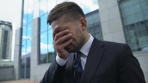 Desperate Man in Business Suit Covering Face With Hands, Losing Job, Bankruptcy