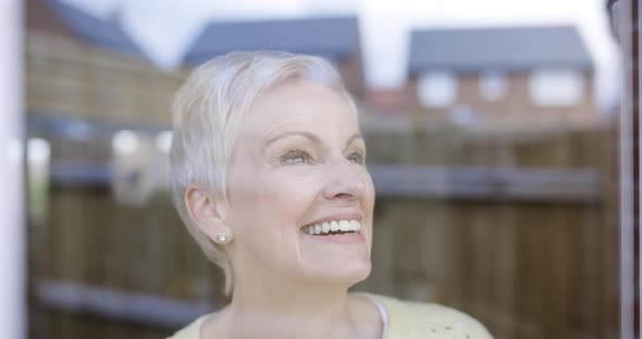 Cheerful woman looking out of window