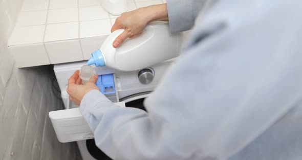 Pouring Conditioner Into a Washing Machine alt