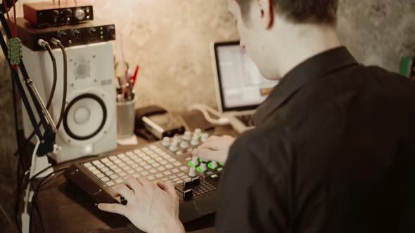 Male DJ Using Soundboard in Home Studio