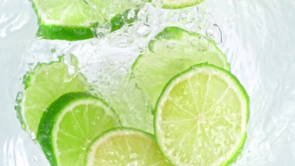 Super Slow Motion Shot of Lime Slices Falling Into Water Whirl at 1000 Fps alt