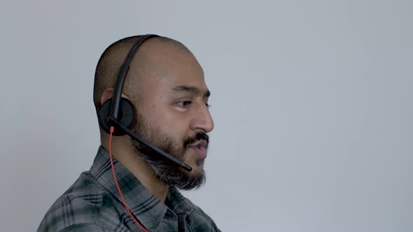 A close up shot of the face of a good looking Asian man speaking into a microphone during a customer alt