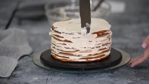 Young Caucasian Woman Making a Layer Cake with Whipping Cream