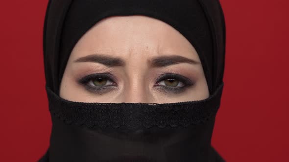 Extreme Close Up Portrait of Oriental Woman with Black Smoky Eyes Wearing Traditional Niqab alt