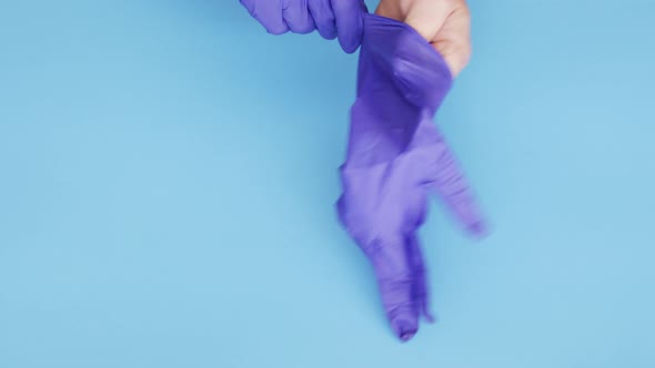 Doctor putting on protective medical latex gloves to protect