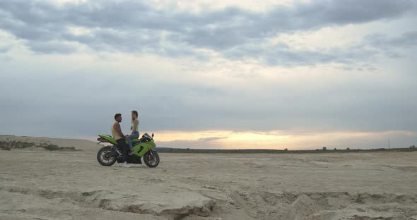 Stylish Couple on Motorbike on Beach