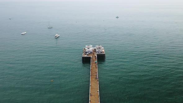 People Loafing Around on Malibu Pier with Boats Littered on the Ocean in California USA - Forward Pa alt