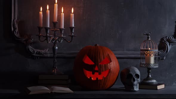 Scary laughing pumpkin and an old skull over the frightening gothic background. alt