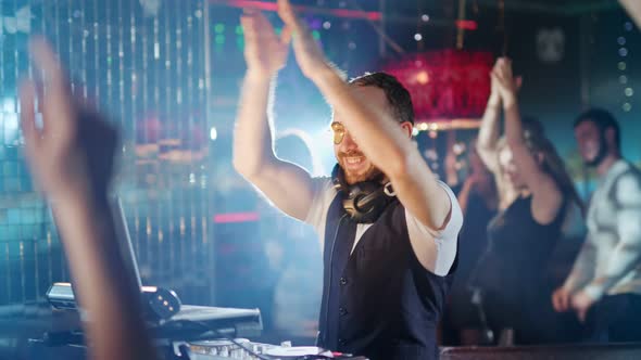 DJ is Playing Music at a Party in a Nightclub alt