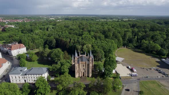 Drone shot of Schlosskirche church in green forest in Neustrelitz, Germany. alt
