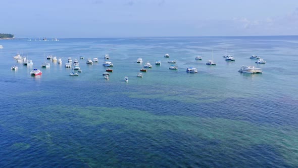 Moored boats on turquoise crystalline sea water of Dominican Republic. Aerial view alt