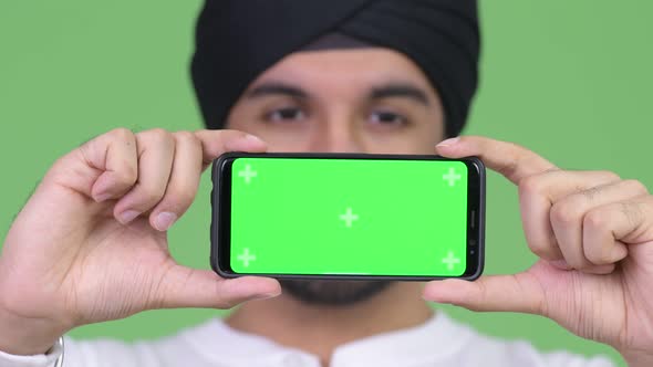 Young Happy Bearded Indian Man Showing Phone