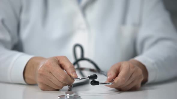 Skilled physician wearing stethoscope, ready to examine patient, health-care