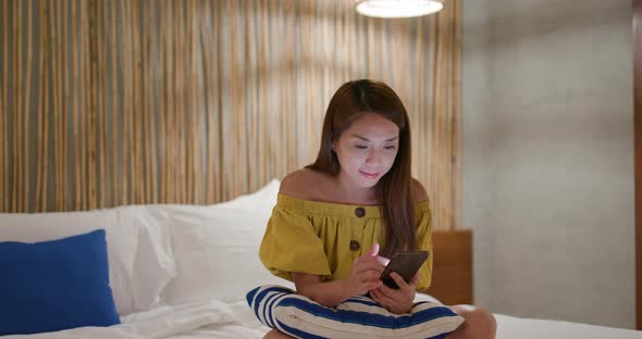 Woman use of mobile phone at hotel room