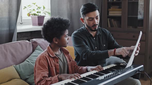 Music Teacher Showing Notes to Boy alt