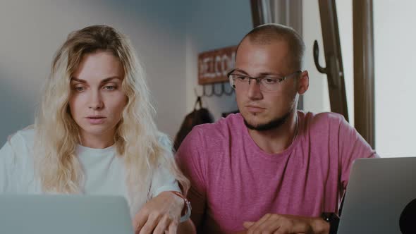 Young handsome man and woman work in cafe with laptop  using laptop browsing online alt