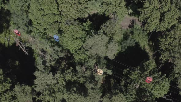 Aerial Drone Shot of a Cable Car Moving Over a Green Forest in Summer on a Synny Day. Kharkiv alt