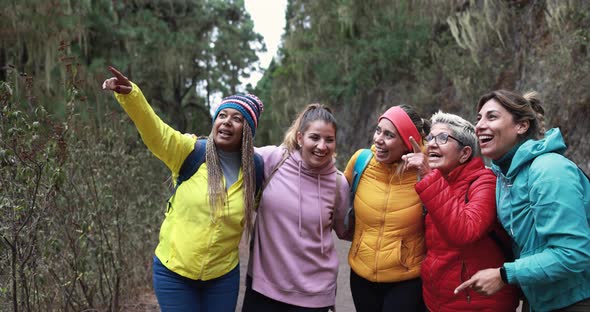 Multiracial women having fun during trekking day in to the wood alt