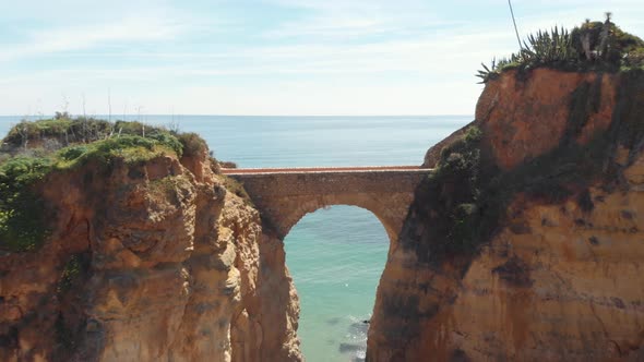Estudante Beach Roman bridge joining eroded cliffs in Lagos, Algarve, Portugal alt