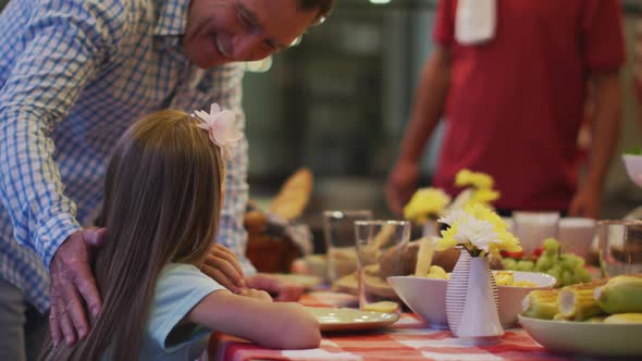 Happy family eating dinner together. alt