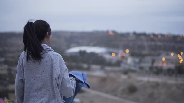 Woman Resting After Exercising Outdoors and Drinking Water After Sunset alt