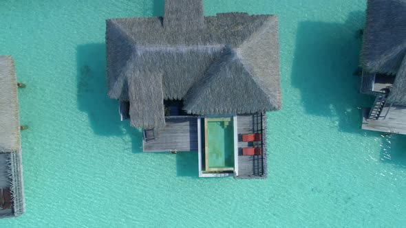 Aerial drone view of a luxury resort and overwater bungalows in Bora Bora tropical island. alt