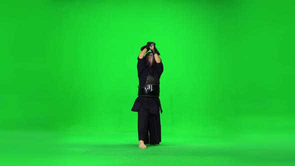 Masculine Kendo Warrior Practicing Martial Art with the Bamboo Bokken on Green Screen. alt