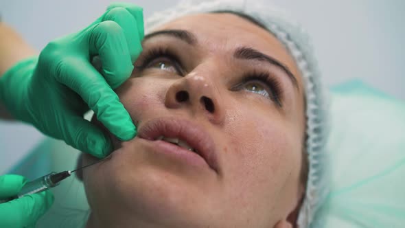 Woman Undergoes Anti-aging Facial Filler Injection in Clinic alt