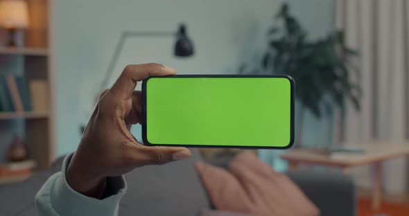 African American Man Holding Modern Smartphone with Green Screen alt