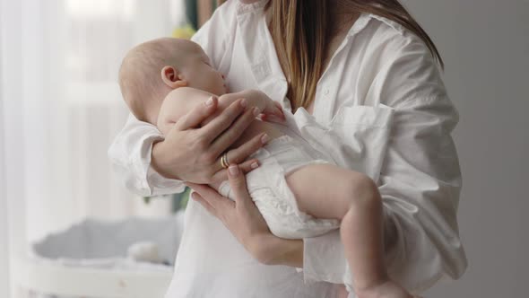 Mother Carrying on Hands Sleepy Newborn Son