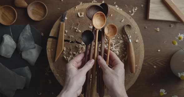 Woman Carpenter Drops Down Bunch of Handmade Wooden Spoons on a Table Close-up alt
