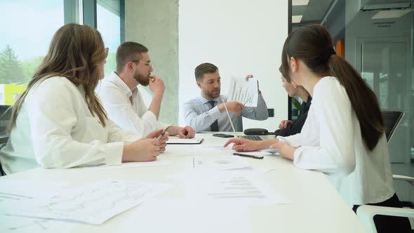 A Group of Young Male and Female Office Employees Sitting and Discussing on a Project in a alt